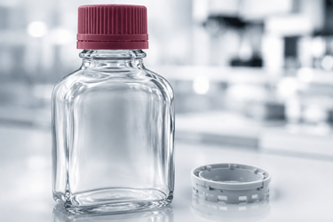 Pharmaceutical glass container with its screw closure highlighted in red and a separate closure component