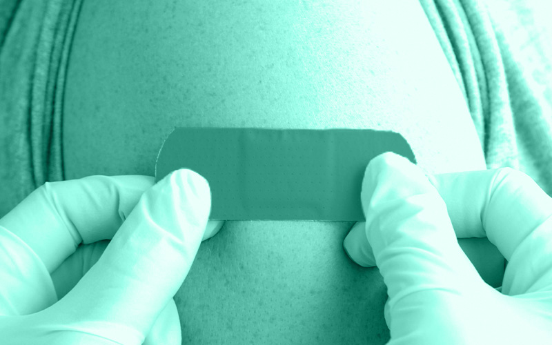 Adhesive bandage being applied to a person’s upper arm