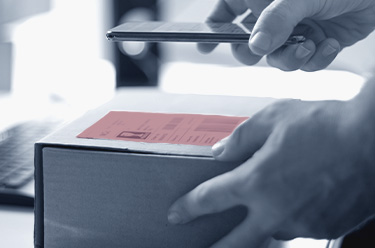 Operator checking a carton label and product marking with a handheld reader