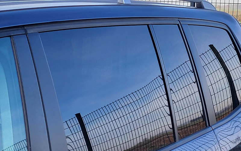[Translate to English (USA):] Reflexionen eines Stabmattenzauns auf den Scheiben eines Autos